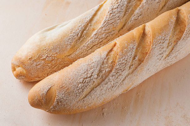 テーブルの上の白い長いフランスパン パン - 写真・画像