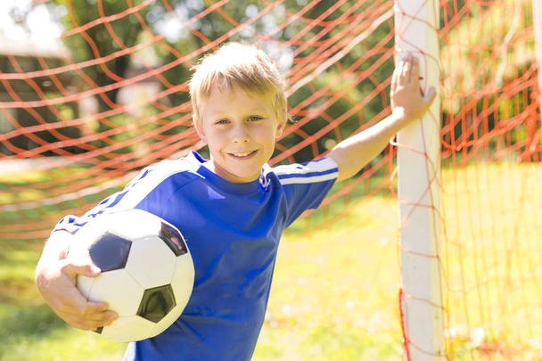 Young boy with soccer ball on a sport uniform - Foto, afbeelding