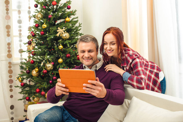 pareja con tableta digital en Navidad
 - Foto, imagen