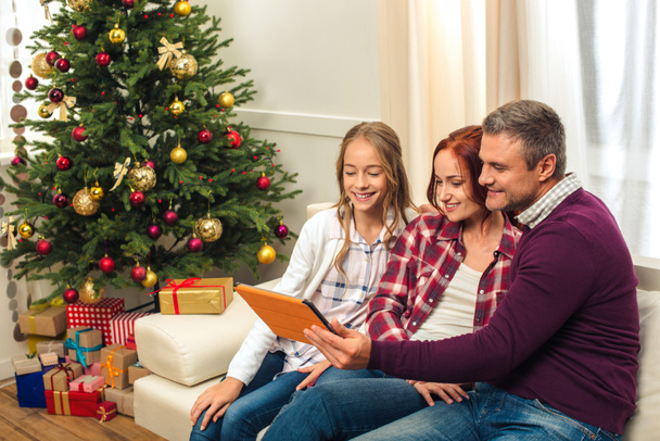 сім'я з цифровим планшетом у різдвяний вечір
 - Фото, зображення