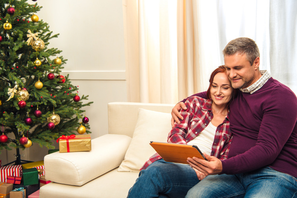 couple with digital tablet at christmastime - Photo, Image