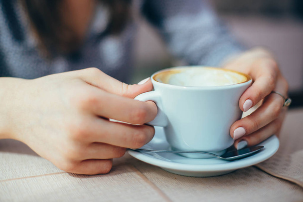 Closeup of mug with coffee in hands of woman - Фото, зображення
