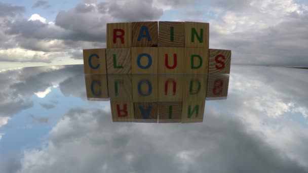 Juguetes de cubos alfabéticos en el espejo con palabra Nubes de lluvia, lapso de tiempo
 - Metraje, vídeo