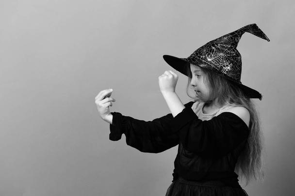 Kid in witch hat, dress and concentrated face - Photo, Image