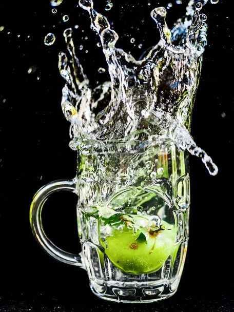 Water splash close-up macro of the cherry as it plunges into the glass of water. - 写真・画像