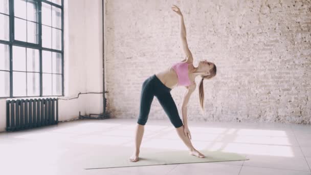Mooie yoga meisje doet asana's in studio - Video
