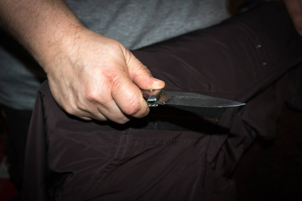 Primer plano de la mano de un joven, sosteniendo un cuchillo, a punto de atacar
 - Foto, imagen