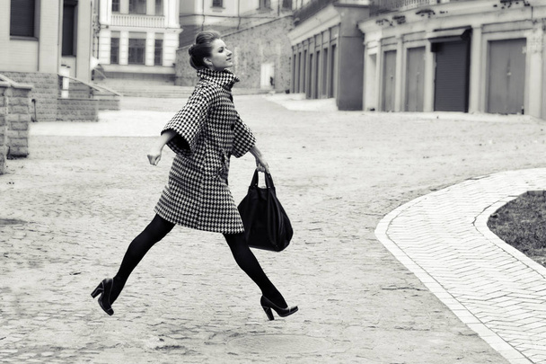fashion and people concept - happy young woman or teenage girl running and jumping high on city street - 写真・画像