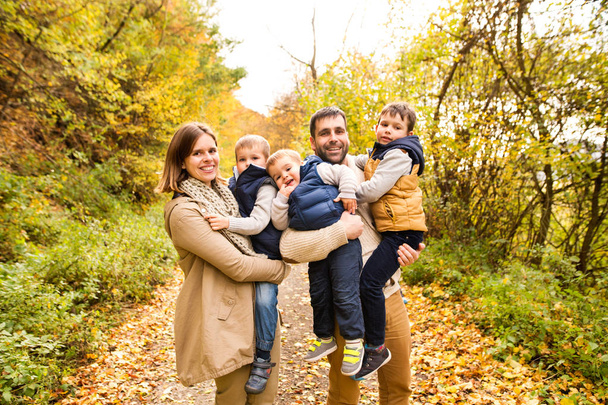 Beautiful young family on a walk in autumn forest. - Foto, Bild