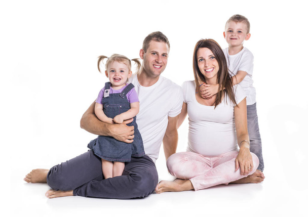 Happy family with two kids on studio white background - Foto, imagen