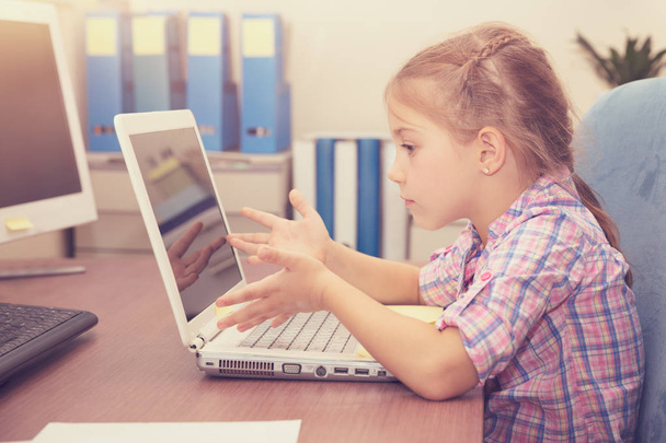 Little girl doing homework on the laptop - Фото, зображення