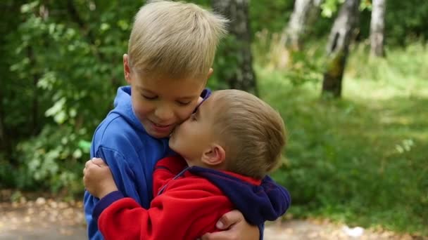 Malé dítě něžně objímat a líbat jeho starší bratr. chlapce objala svého mladšího bratra - Záběry, video