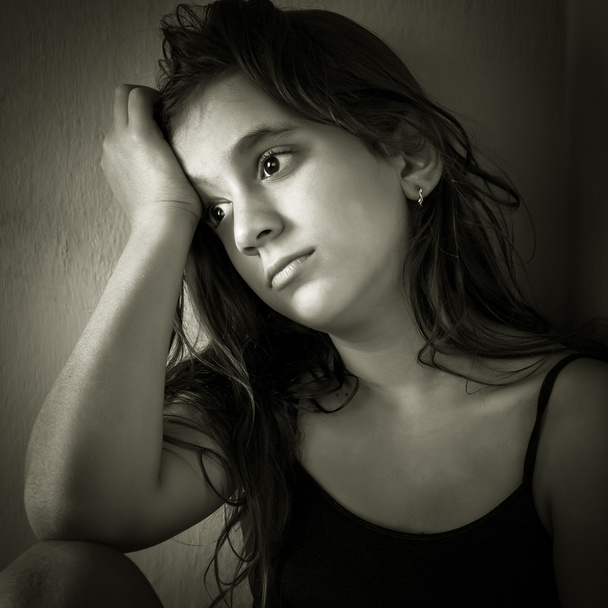 Sad hispanic girl sitting in a corner - Foto, Imagen