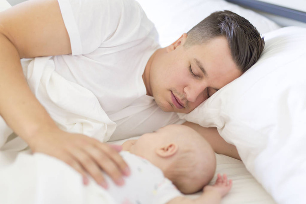 Portrait of father with her 3 month old baby in bedroom sleeping - Photo, image