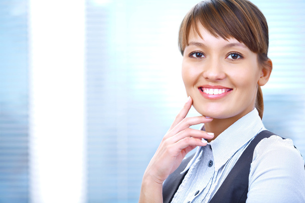 Portrait of a young businesswoman smiling against the office background - Fotó, kép