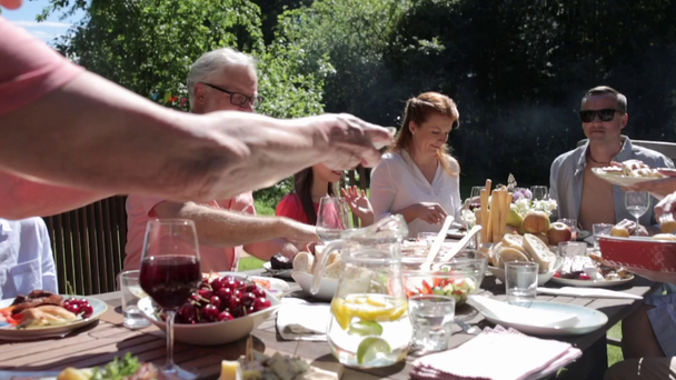 familia feliz cena o fiesta de jardín de verano - Imágenes, Vídeo