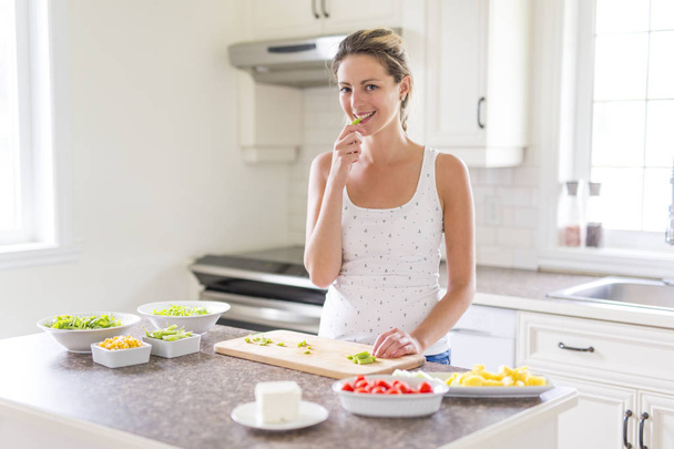 Gorgeous woman doing a salad in her kitchen - Photo, image