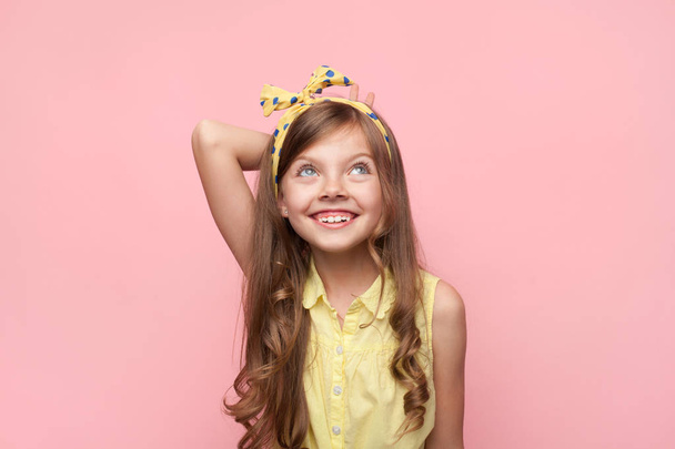 Smiling girl wearing bow looking up - Фото, зображення