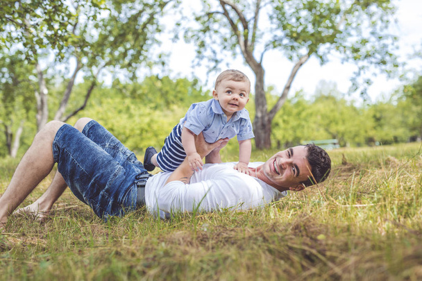 beautiful father little toddler son on the meadow. - Φωτογραφία, εικόνα