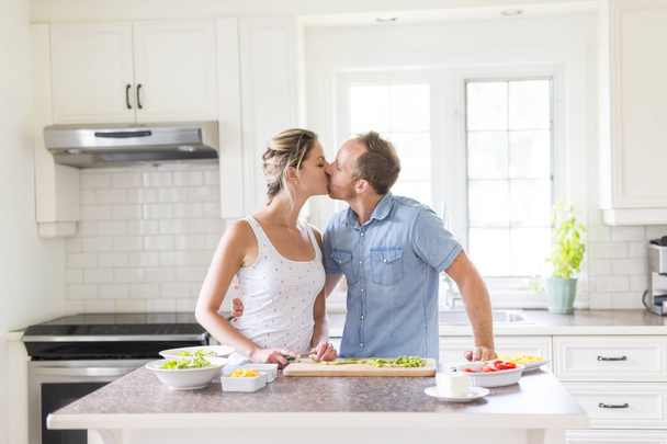 couple in the kitchen doing salad together - Foto, imagen