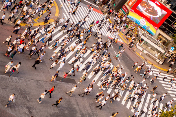 TOKYO, JAPAN JUNE 28 - 2017: Top view of crowd of people crossing in Shibuya street, one of the busiest crosswalks in the world, in the Ginza District in Tokyo - Foto, immagini