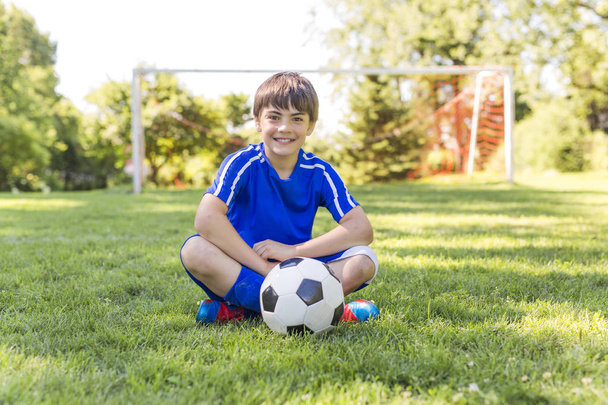 Young boy with soccer ball on a sport uniform - Fotografie, Obrázek