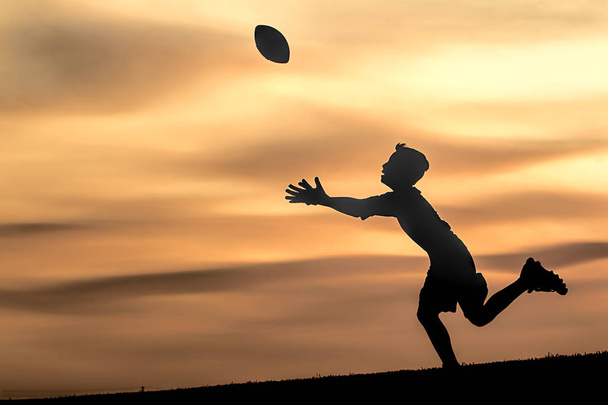 Silhouette of boy going to catch the ball. - Photo, Image