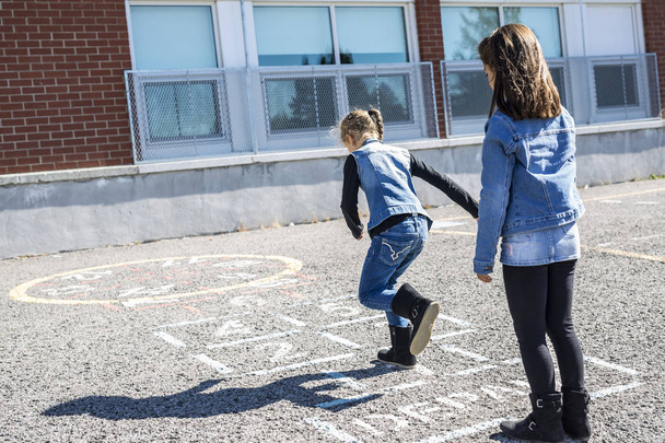 Hopscotch op het schoolplein met vrienden spelen samen - Foto, afbeelding