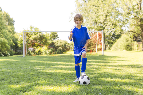 Young boy with soccer ball on a sport uniform - Фото, зображення