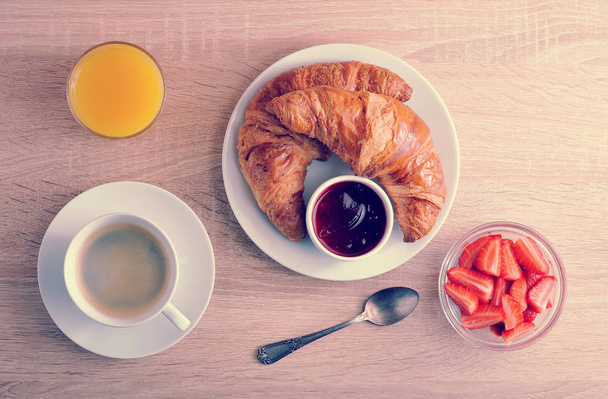 continental Breakfast - coffee, croissant with jam, strawberries - Foto, afbeelding