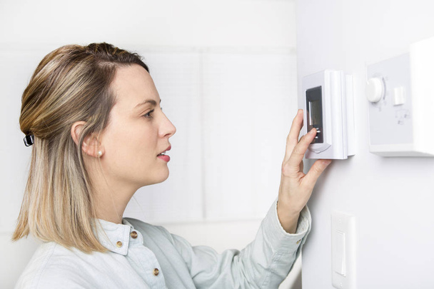 woman set the thermostat at house. - Photo, image