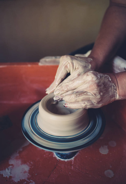 Work in a pottery workshop, womans hands creating ceramics. - Foto, afbeelding