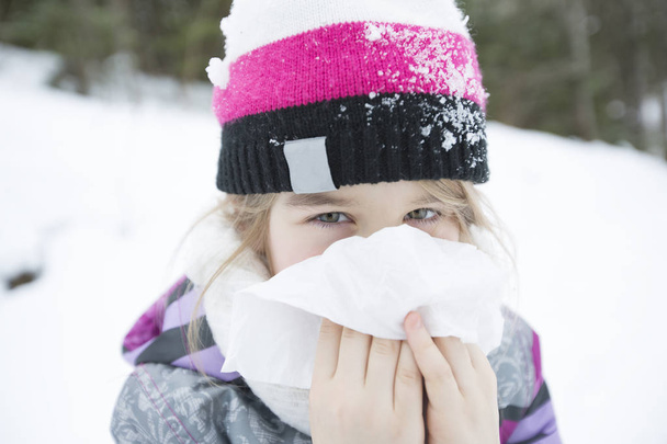 child with tissue outside in forest winter season - Foto, Imagen