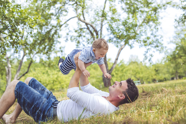 beautiful father little toddler son on the meadow. - 写真・画像