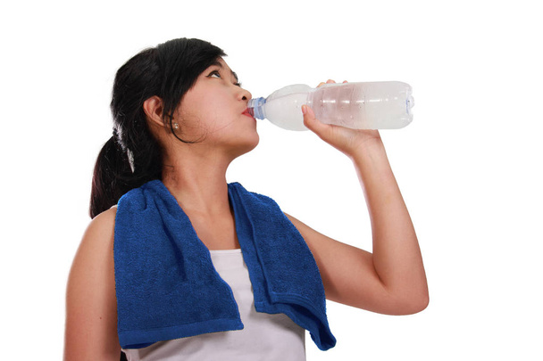 Dziewczyna azjatyckich sportowy napoje za butelkę wody, po stronie widok zbliżenie strzał, izolowana na białym tle - Zdjęcie, obraz