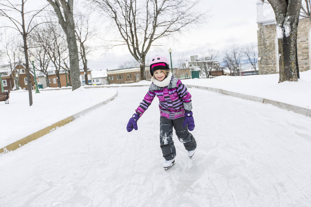 little girl enjoying ice skating in winter season - Fotó, kép