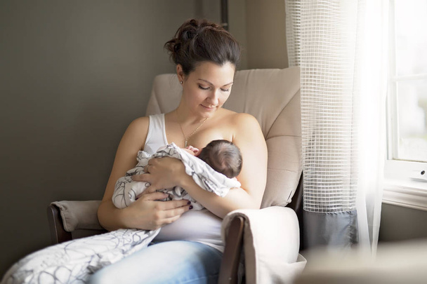 Mother breastfeeding her little baby boy in  arms. - Фото, зображення