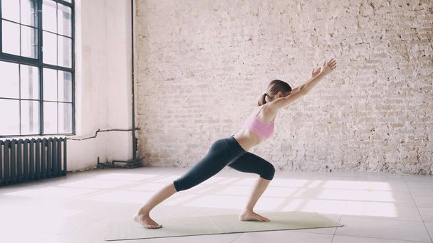 Beautiful yoga girl doing asanas in studio - Photo, Image