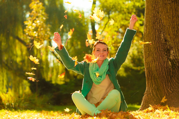 Ευτυχισμένη γυναίκα ρίχνει φθινόπωρο αφήνει στο πάρκο - Φωτογραφία, εικόνα