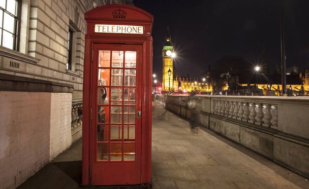 Rode telefooncel nachts, de Big Ben in de verte, Londen, U - Foto, afbeelding