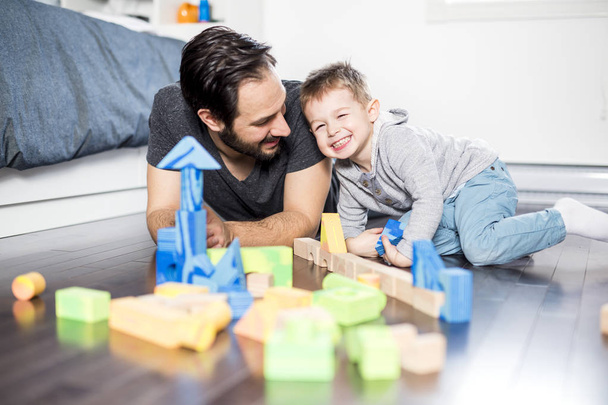 cute child playing with color toy indoor with is dad - Foto, Imagen