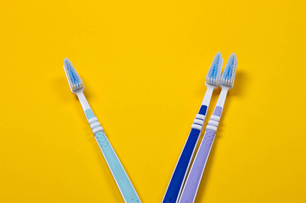 three Toothbrushes on yellow background - Photo, Image