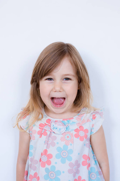 retrato divertido de niña rubia pequeña boca abierta riendo
 - Foto, Imagen