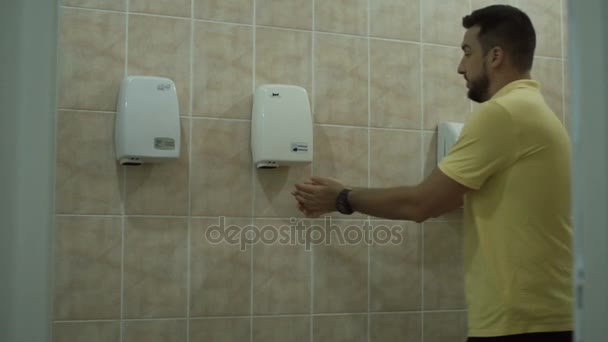 De man is zijn handen in het toilet drogen - Video