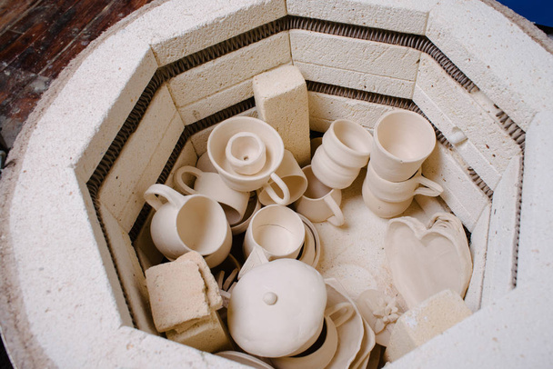 Geroosterde keramische producten zonder glazuur in de potter's handen. Aan - Foto, afbeelding
