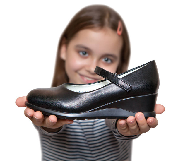 Happy girl holding in hand in front of a black Shoe - Foto, imagen