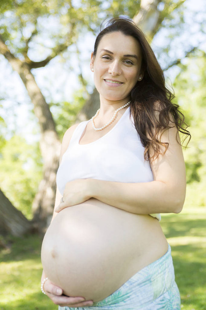Young beautiful pregnant woman with long hair - Φωτογραφία, εικόνα