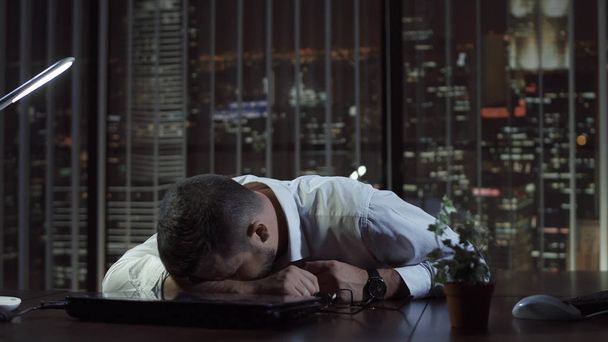 Hombre agotado durmiendo en la oficina
 - Foto, Imagen