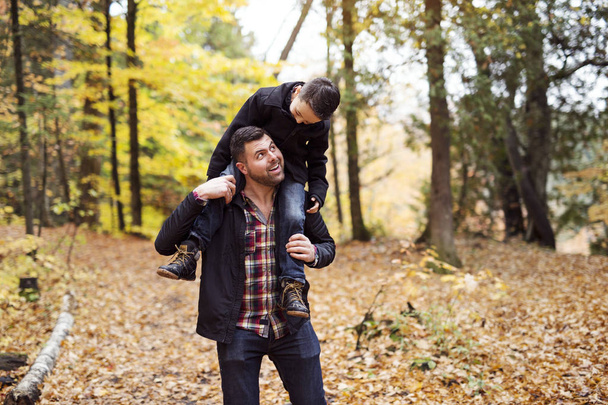 father and son having fun in autumn park - Fotoğraf, Görsel