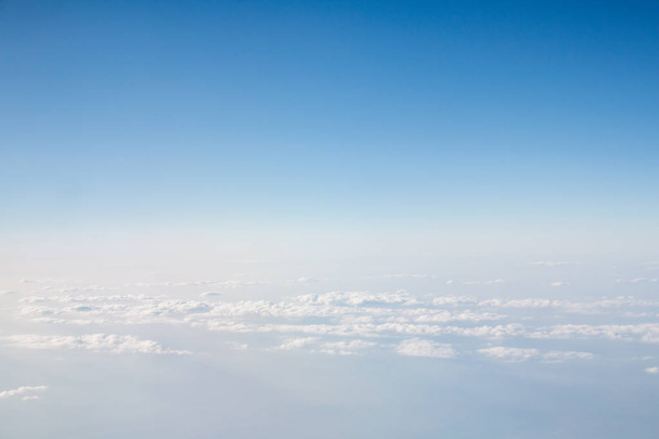 blauwe hemel met wolken achtergrond. uitzicht vanaf vliegtuig - Foto, afbeelding